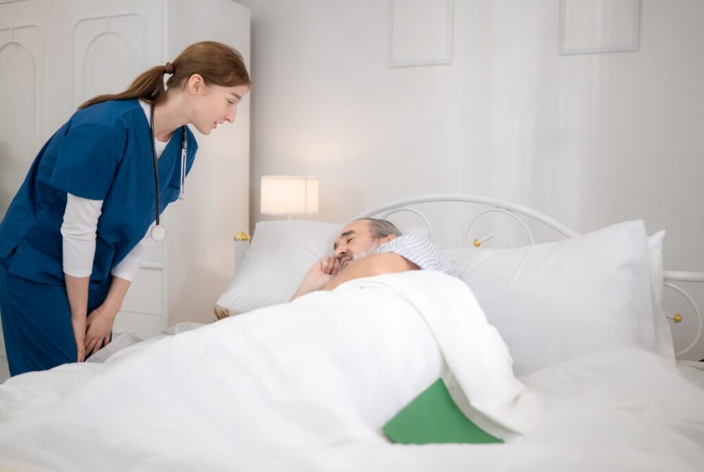 Infermiera che assiste un anziano a letto in una struttura